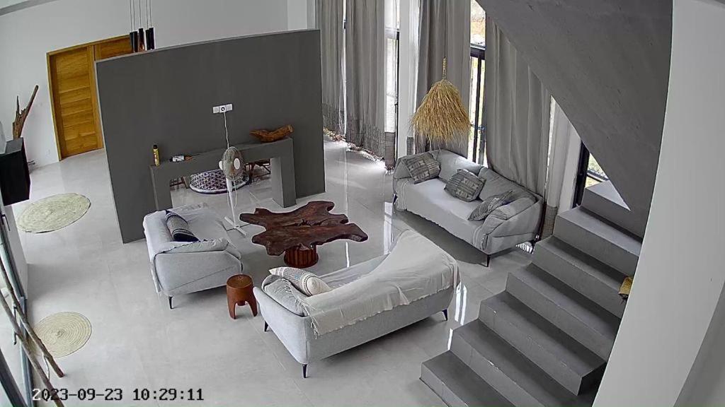 a living room with couches and a table and a staircase at NDARI in Siendou