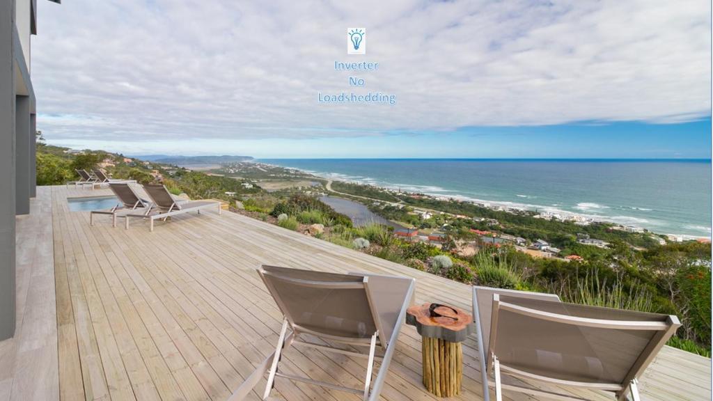 Un balcón con sillas y vistas al océano. en Kooboo Berry Ocean View, Self Catering Guesthouse, en Wilderness