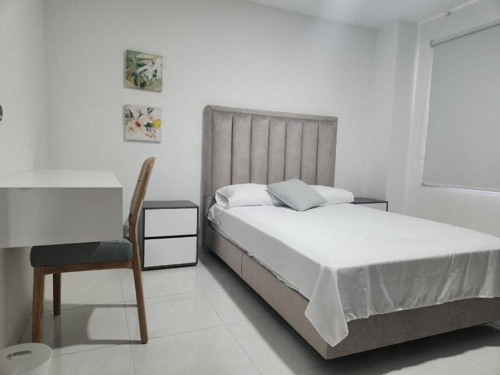 1 dormitorio blanco con 1 cama y 1 silla en Hermoso apartamento, en Pitalito