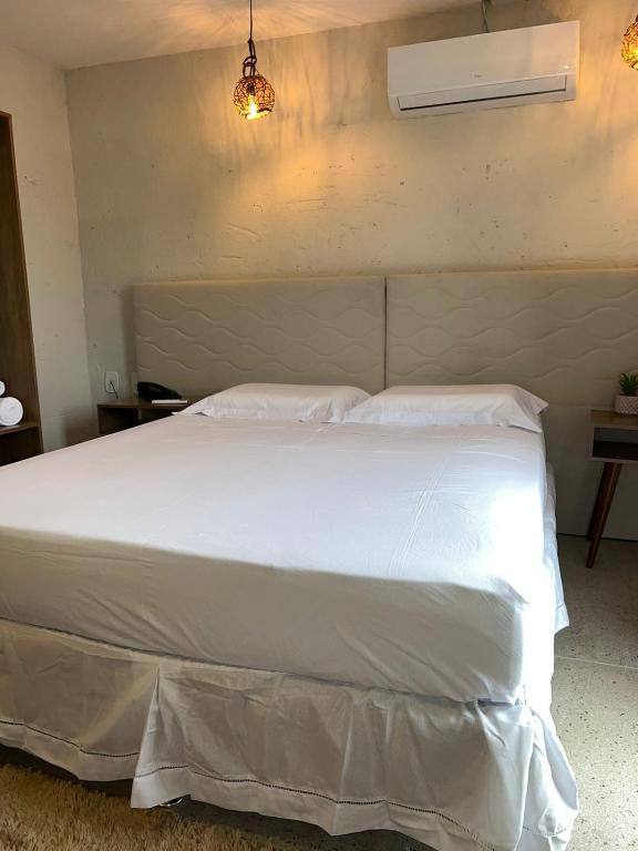 a bedroom with a large white bed in a room at NOAH Rústico Hotel in Bôca da Mata