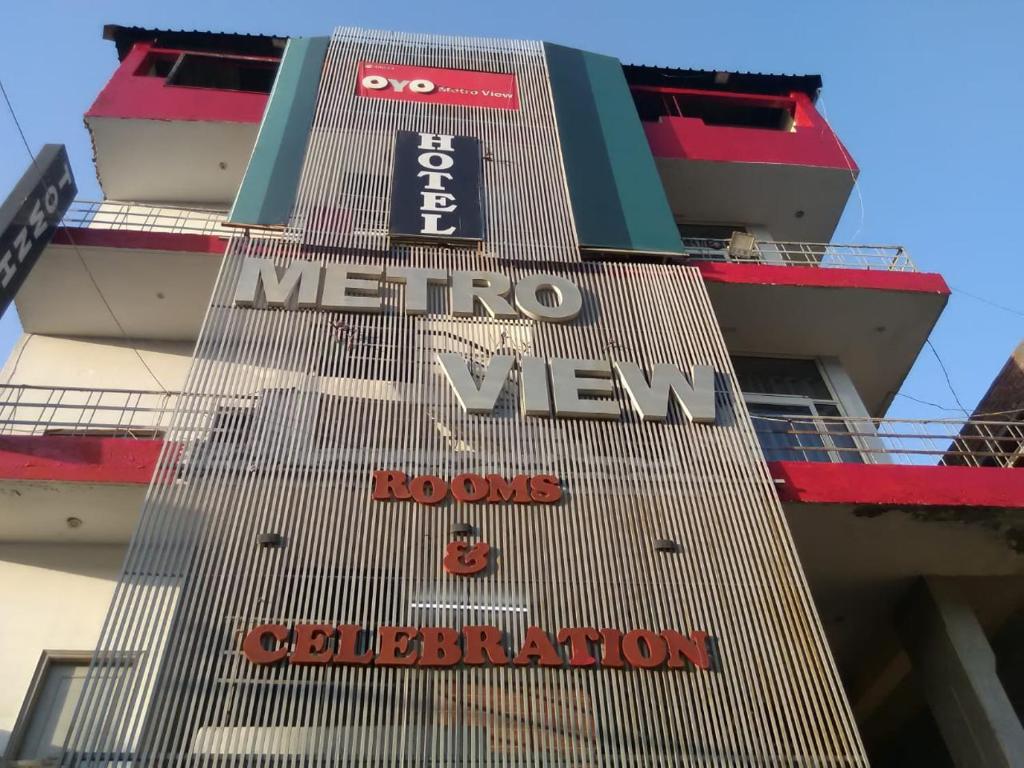 a tall building with signs on the side of it at Metroview rooms & hotel in Bahādurgarh