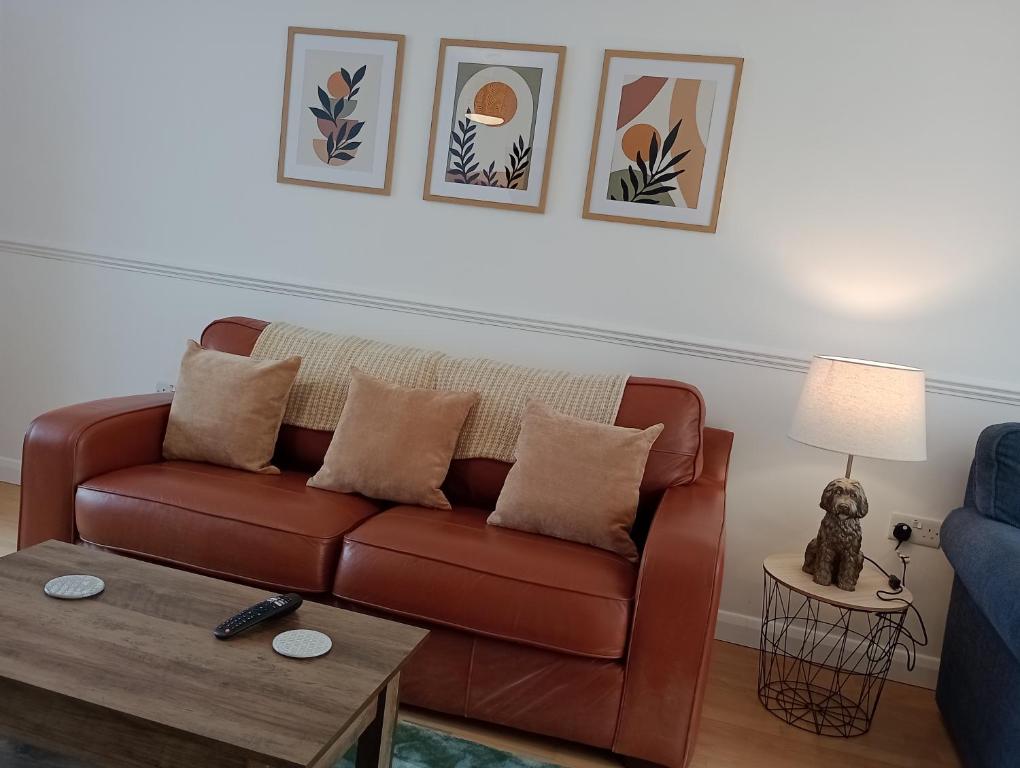 sala de estar con sofá marrón y mesa en 3BR House with garden near Bicester Village en Bicester