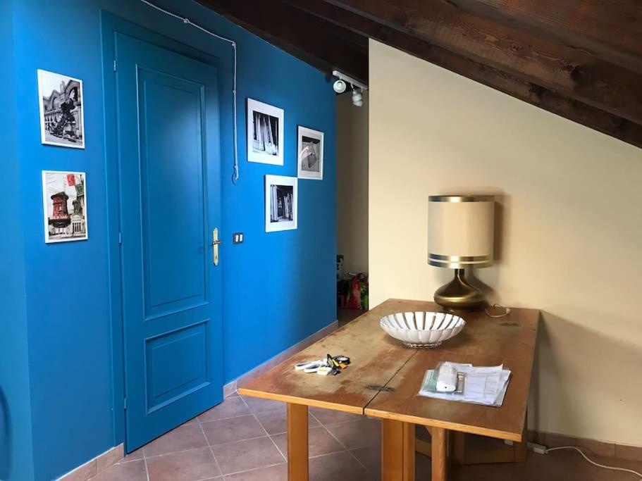 Cette chambre dispose d'une porte bleue et d'une table en bois. dans l'établissement da nonna Emi, à Modène