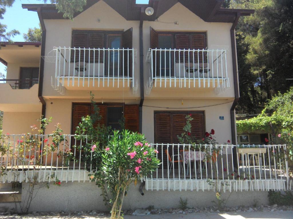 una casa con balcones blancos y flores delante de ella en Vila Mitko, en Star Dojran