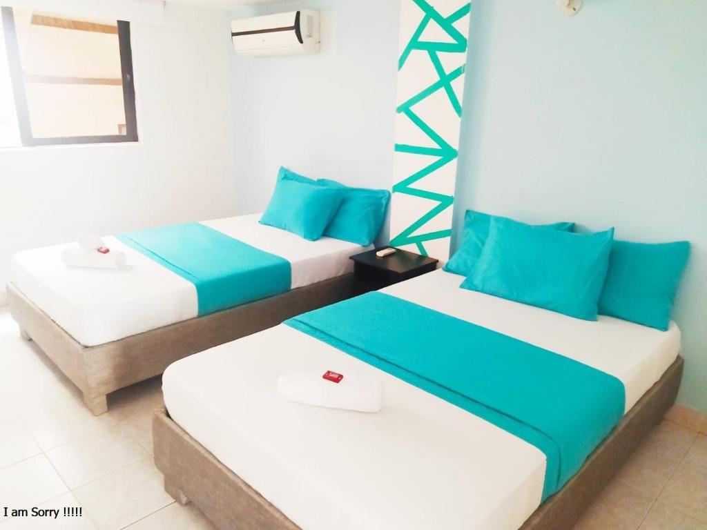 2 camas en una habitación de color azul y blanco en APT en EDF Frente a la playa y cercano centro Histórico 1-2, en Cartagena de Indias