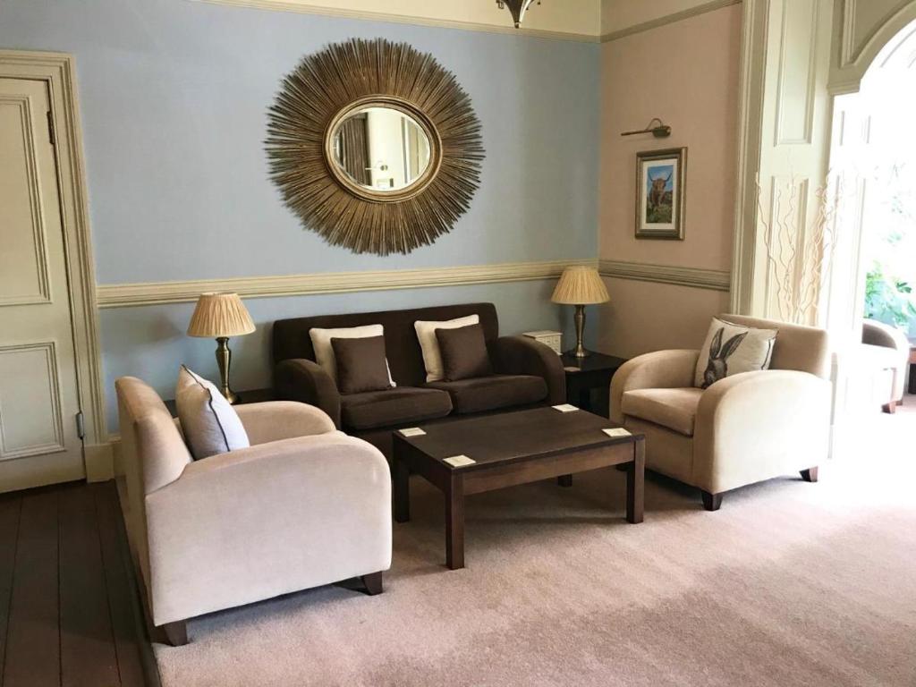 a living room with two chairs and a mirror at The Abbotsford in Callander