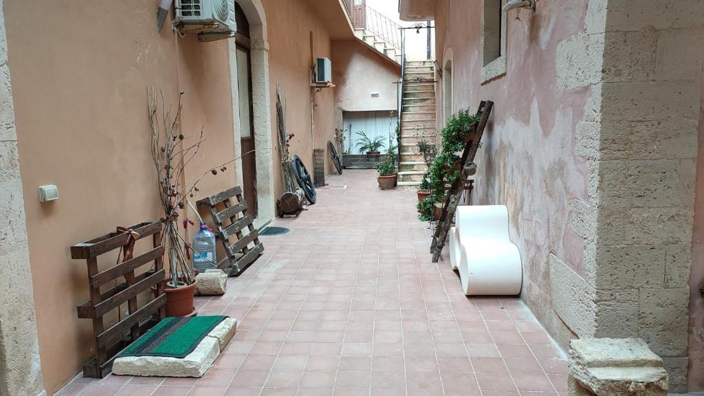 een steegje met planten aan de zijkant van een gebouw bij Palazzo Gancia holiday homes in Siracusa