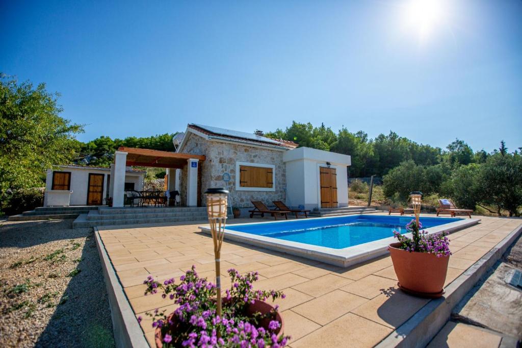 a villa with a swimming pool and a house at Olive Garden House in Šibenik