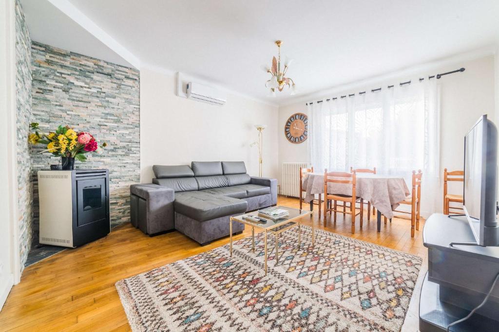 a living room with a couch and a table at Les Rosiers - Maison avec JACUZZI in Brive-la-Gaillarde