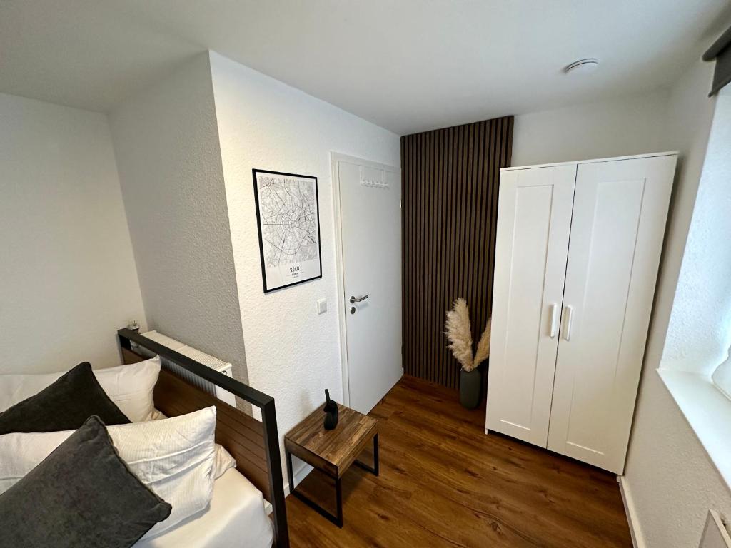 ein Schlafzimmer mit einem Bett und einem Tisch in einem Zimmer in der Unterkunft Modernes Apartement am Rhein in ruhiger Lage in Köln