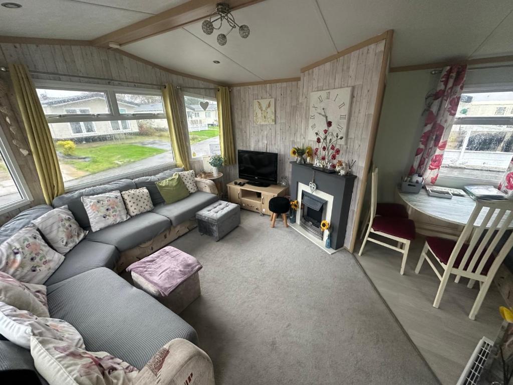 - un salon avec un canapé et une télévision dans l'établissement Robin Hood Rhyl caravan oaklands, à Rhyl