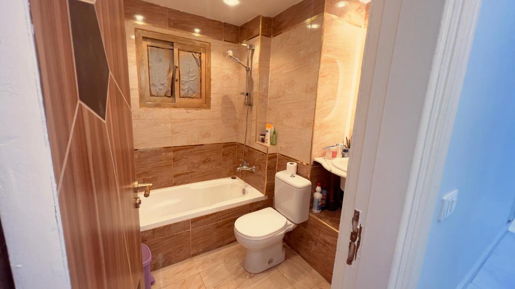 een badkamer met een toilet, een bad en een wastafel bij Luxury Stay at Mokktam Heights in Caïro