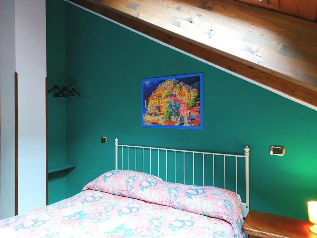 een slaapkamer met groene muren en een bed met een sprei bij La Locanda del Pettirosso in Agerola