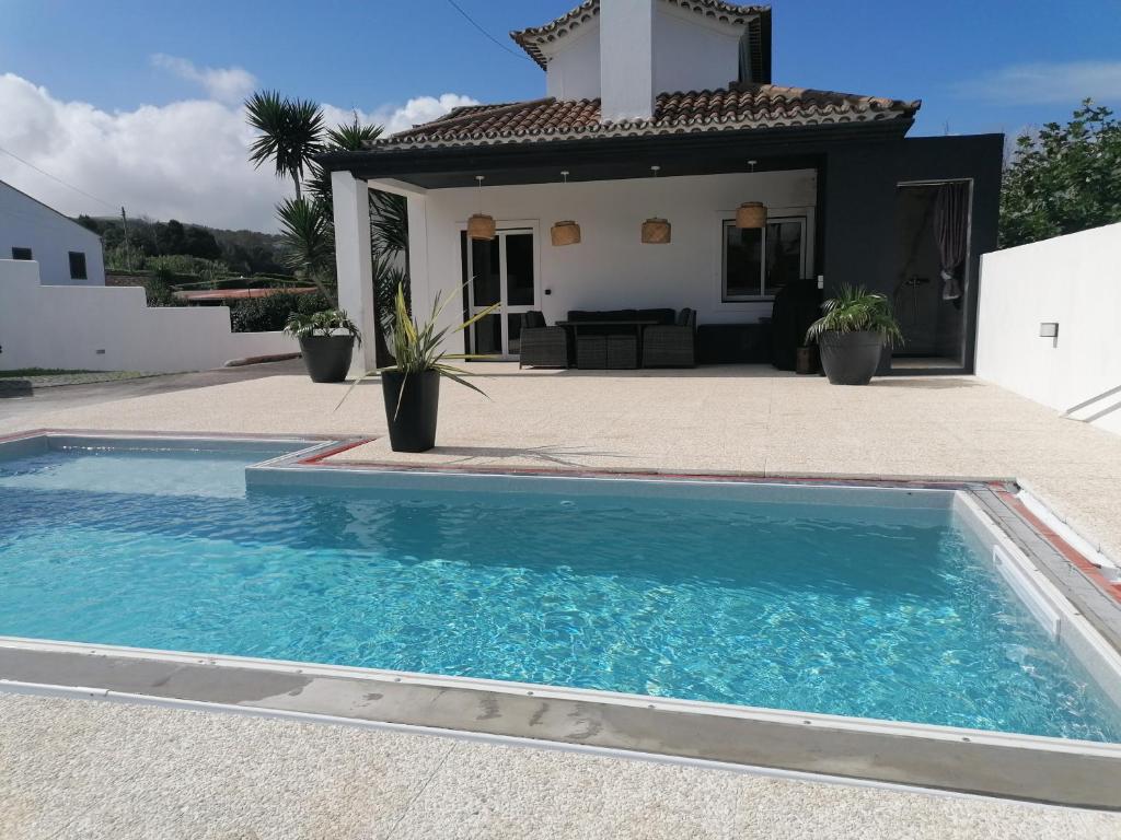 uma villa com piscina em frente a uma casa em Espaço Roteiro de Mimos em São Vicente Ferreira