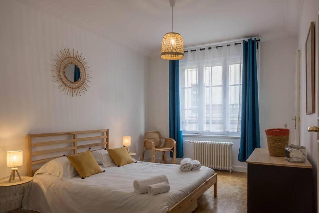 Schlafzimmer mit einem großen Bett und blauen Vorhängen in der Unterkunft Le Chambellan in Orléans