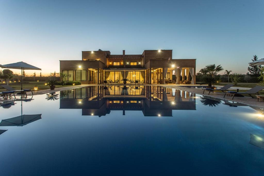 une villa avec une piscine la nuit dans l'établissement L'Orientale By La Siredrah, à Marrakech