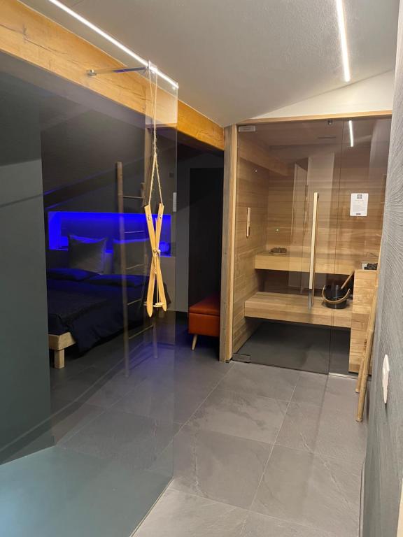 sypialnia z niebieskim łóżkiem i szklaną ścianą w obiekcie Hotel Veduta dell'Adamello w mieście Temù