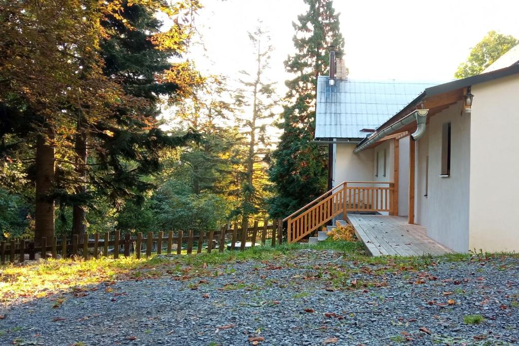 ein Haus mit einer Holzrampe neben einem Zaun in der Unterkunft Chachata - Jeseníky - polosamota in Dolní Moravice