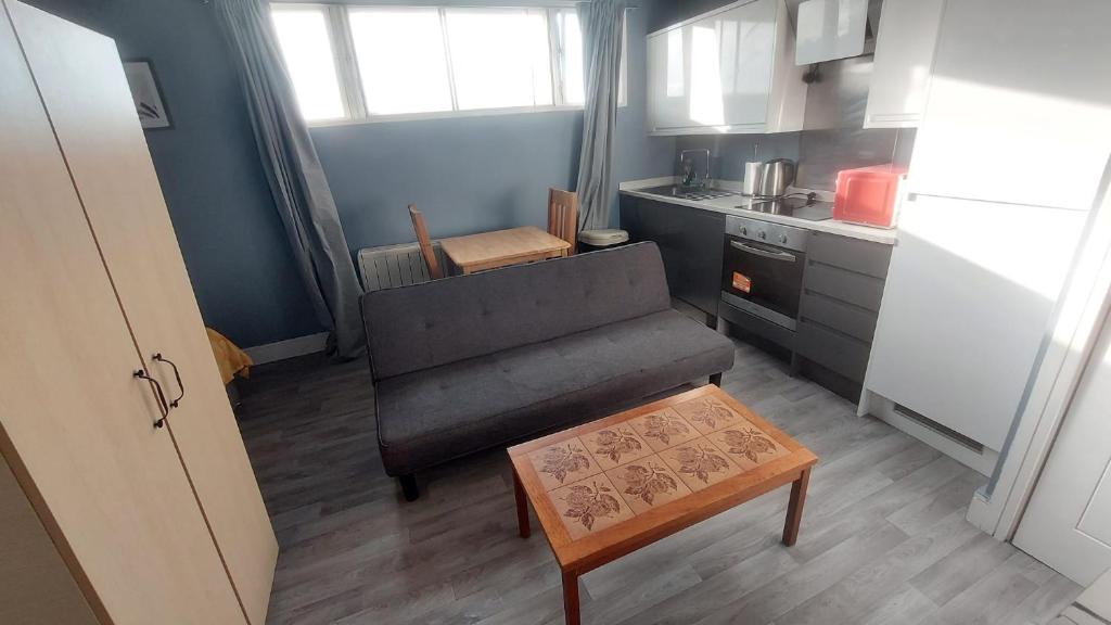 ein kleines Wohnzimmer mit einem Sofa und einem Tisch in der Unterkunft Modern Studio Maidstone - Redecorated Oct 2023 in Maidstone