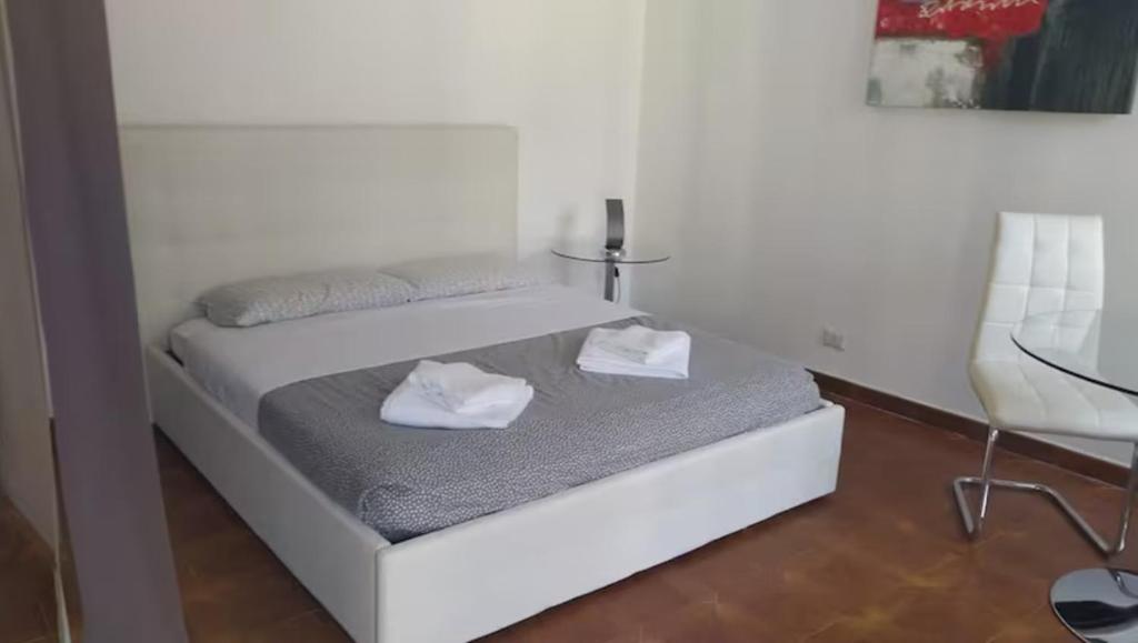 a white bed with two white towels on it at ROSSO MAGENTA - Luminoso loft in centro e a due passi dalla stazione in Turin
