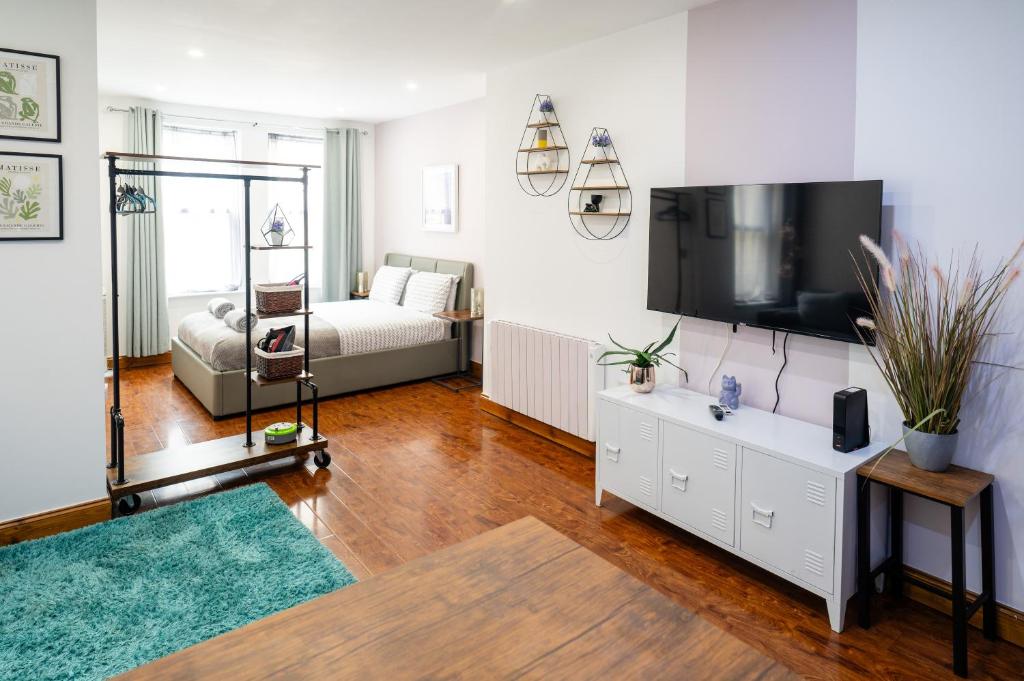 a living room with a television and a couch at REEF7 - Modern central flat, 5 mins from beach, centre and Bournemouth International Centre in Bournemouth
