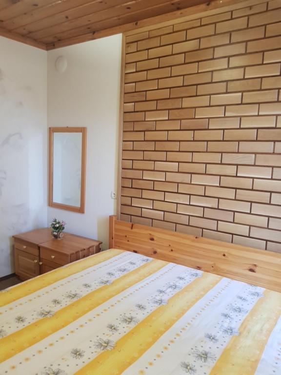 een slaapkamer met een bakstenen muur en een bed bij Wine Boutique Complex ,,Hrisimov" in Musomishta