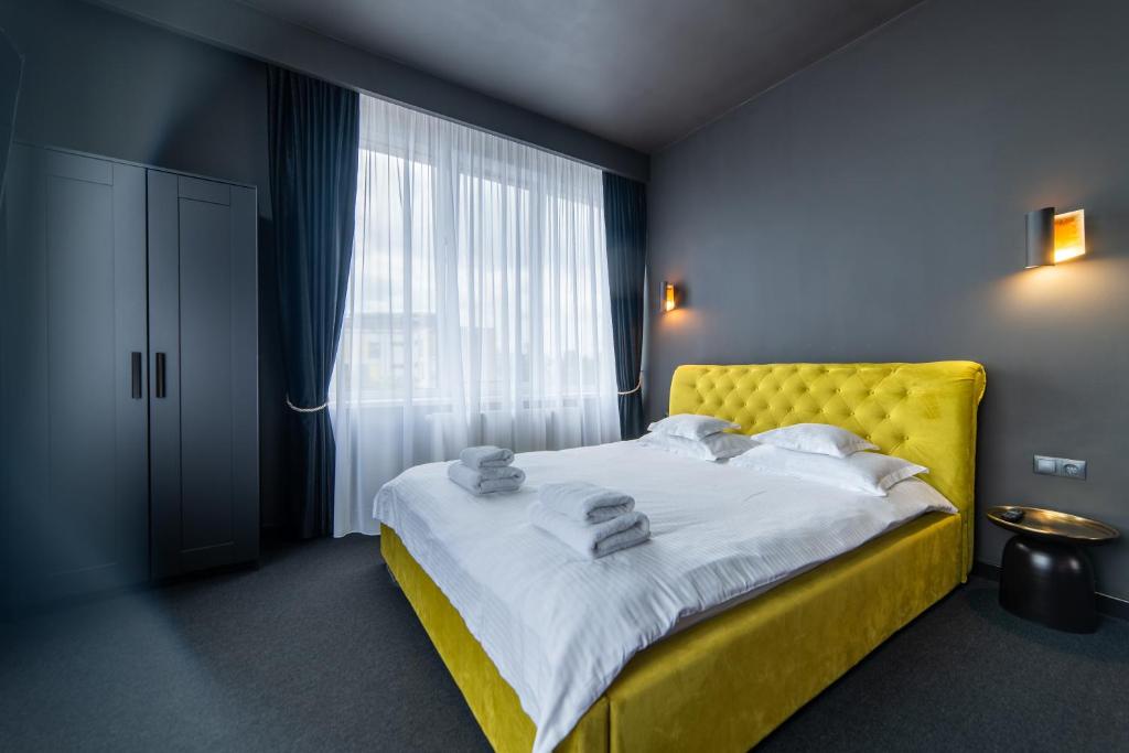 a bedroom with a yellow bed and a window at Zero in Cluj-Napoca