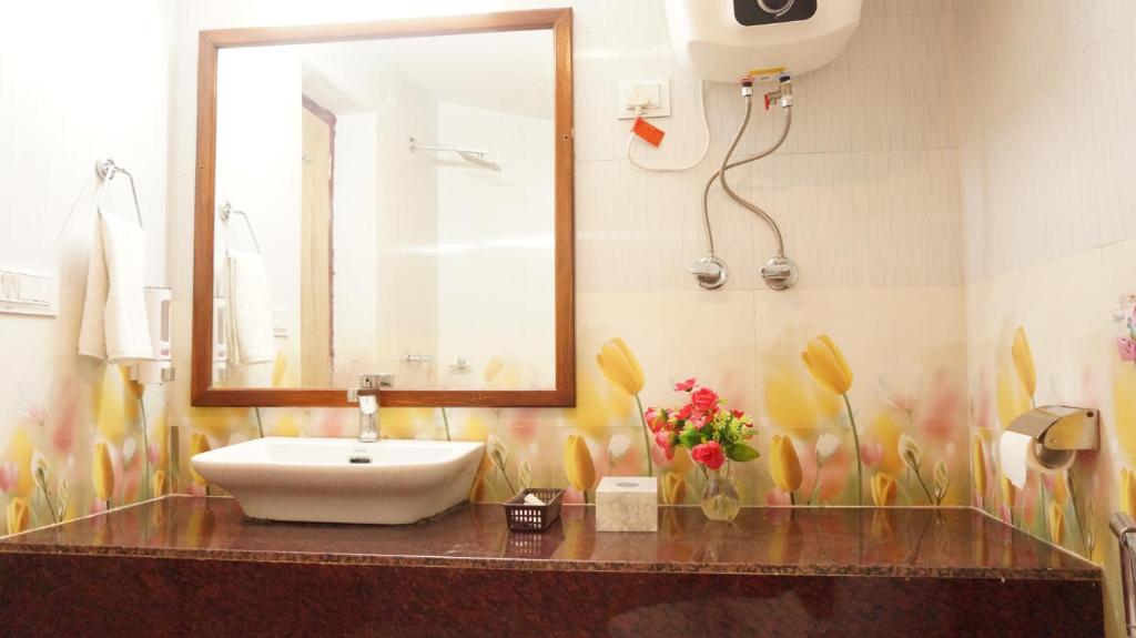 ein Bad mit einem Waschbecken und einem Spiegel in der Unterkunft Wow Relish in Alwar