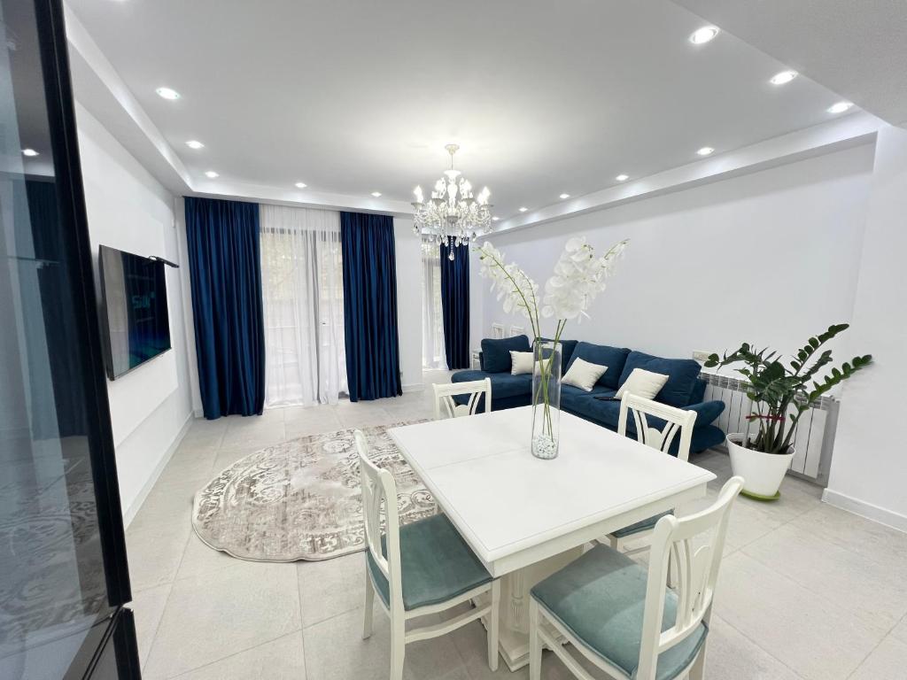 une salle à manger avec une table et des chaises blanches dans l'établissement White bridge apartment, à Koutaïssi