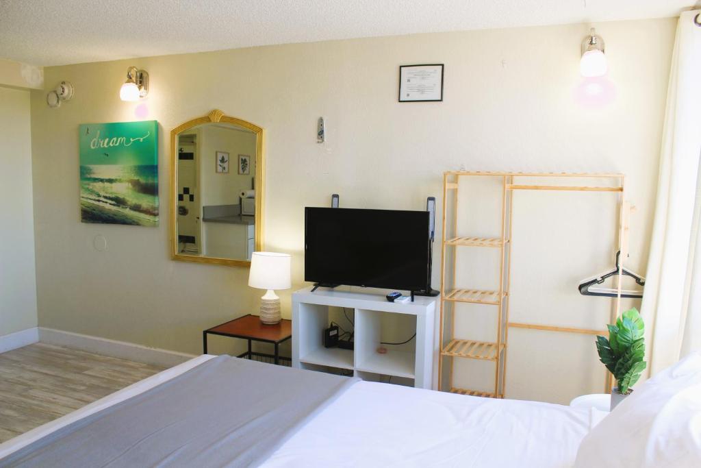 a bedroom with a bed and a flat screen tv at Hawaiian Monarch 1915 condo in Honolulu