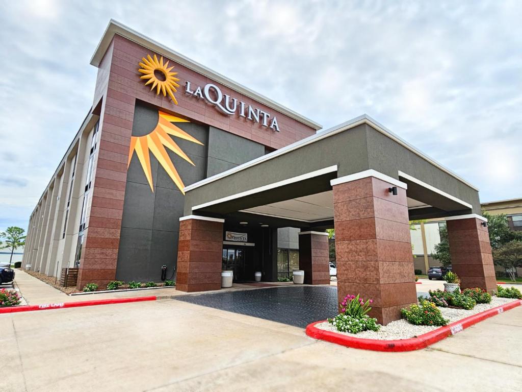 a building with a sunflower on the side of it at La Quinta by Wyndham Houston Stafford Sugarland in Stafford