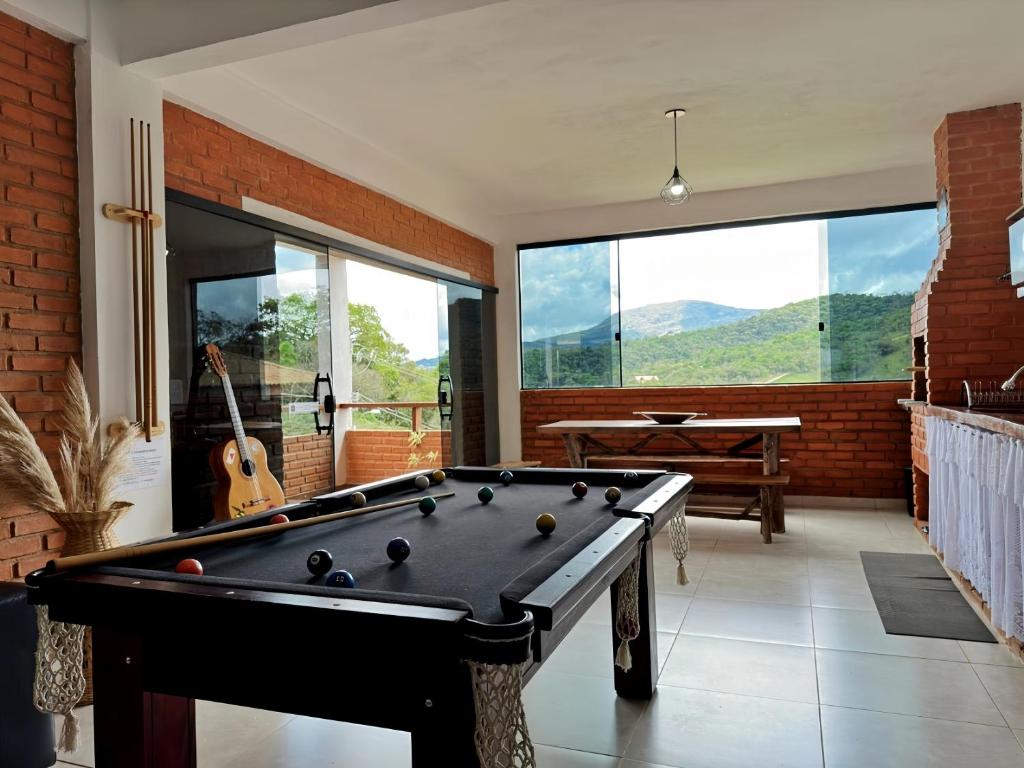 a pool table in a living room with a view at Casa Amantes da Serra Ibitipoca - Sua melhor opção! in Conceição da Ibitipoca