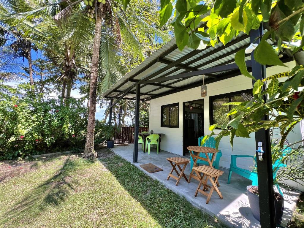 a patio with a table and chairs on a house at Rinconcito Magico beachfront location in Punta Uva