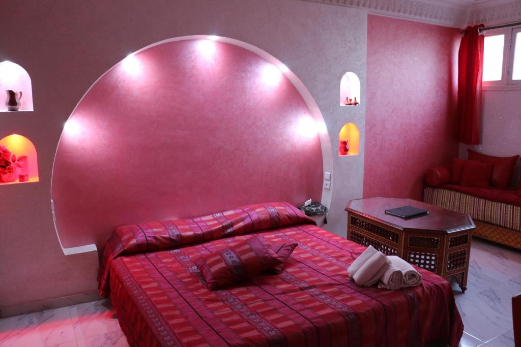 1 dormitorio con 1 cama grande de color rojo y espejo grande en Riad Les Chtis D'Agadir, en Agadir