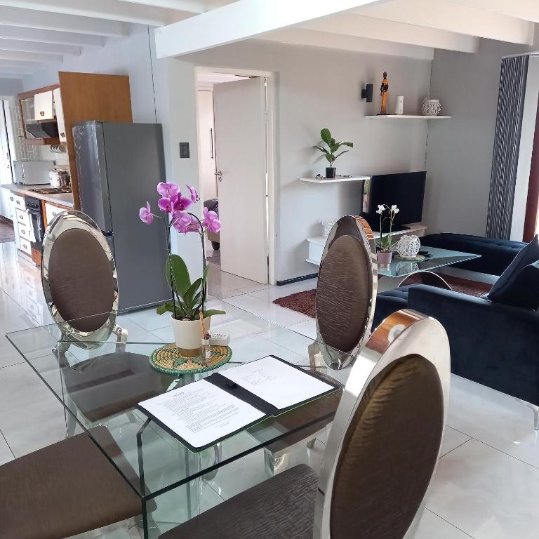 a living room with a glass table and chairs at Crest Farm Cottage in Waterfall