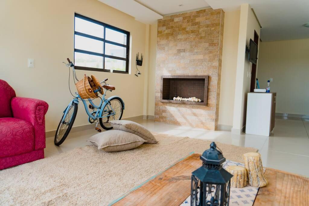 een woonkamer met een fiets en een open haard bij Casa em Bananeiras - Condomínio Caminhos da Serra in Bananeiras