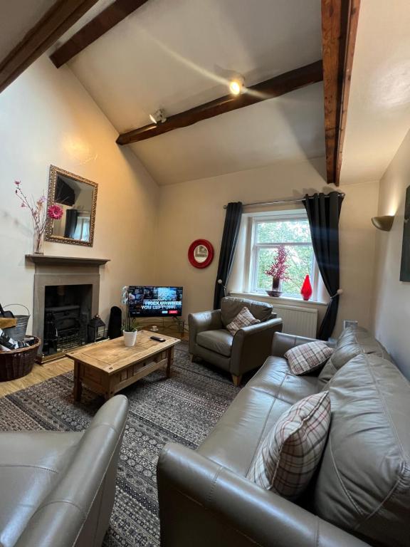 sala de estar con sofá y mesa en Stackhouse flat, en Burnley