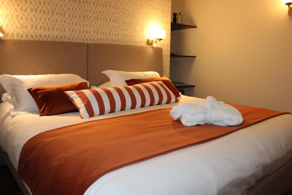 a bedroom with a large bed with towels on it at Hôtel La Truffe Noire in Brive-la-Gaillarde