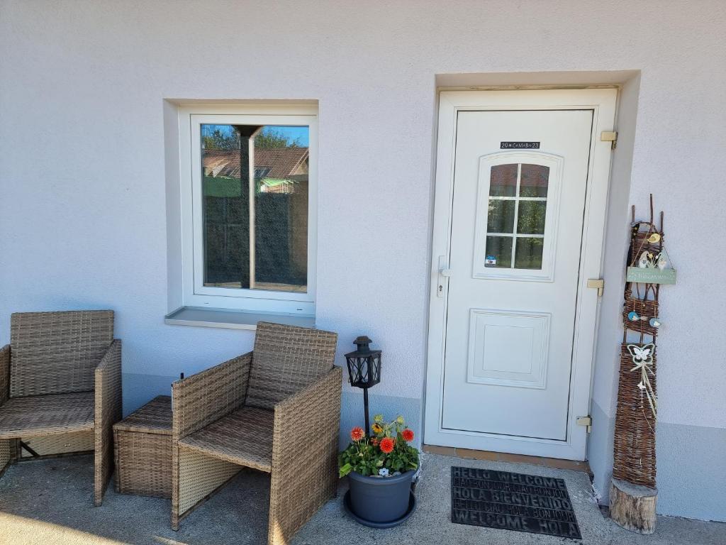 a porch with two chairs and a door at Ferienwohnung im alten Milchwerk in Görisried