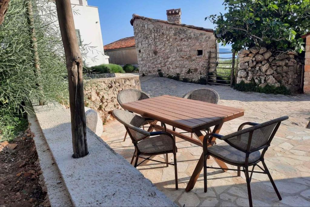 a wooden table and chairs on a patio at Holiday home in Vidovici - Insel Cres 43064 in Vidović