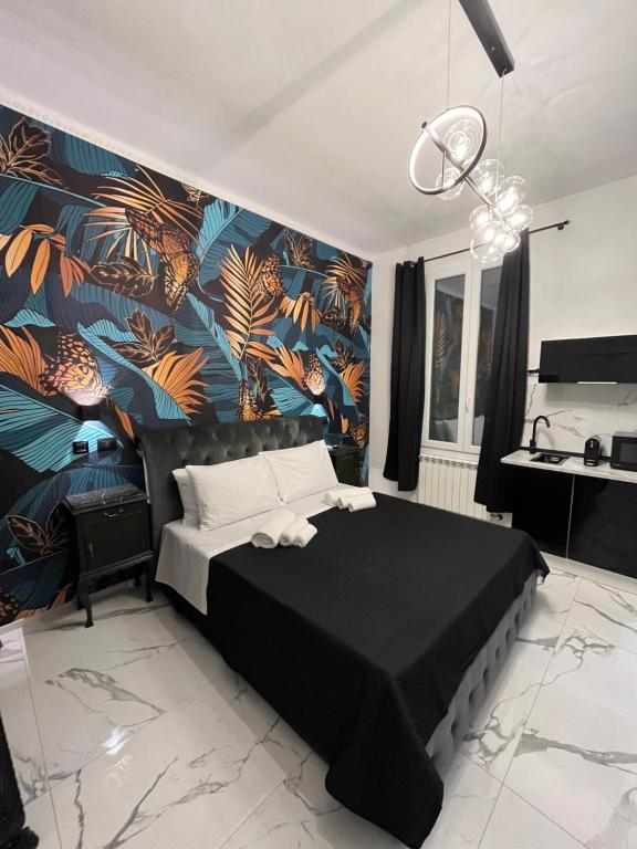 a bedroom with a black bed with a tropical wallpaper at Suites - ghibellina 92 in Florence