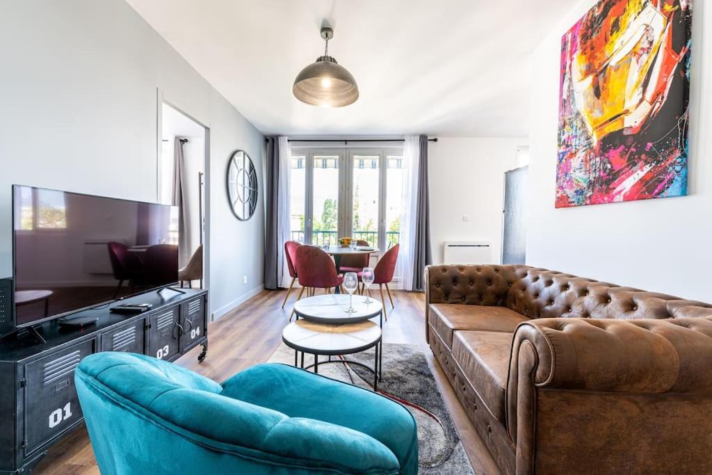 un soggiorno con divano e tavolo di Esprit Marvel: 2 chambres- fibre- balcon- parking a Grenoble