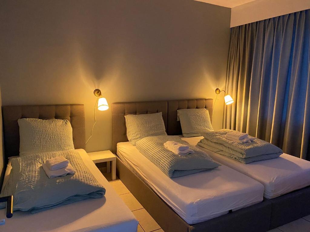 2 Einzelbetten in einem Zimmer mit 2 Lampen in der Unterkunft Bnb Antwerp SportPlaza in Antwerpen