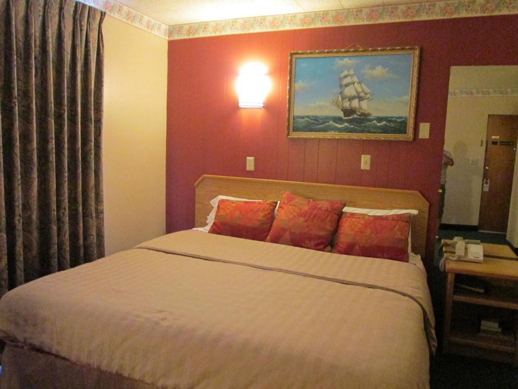 a bedroom with a large bed with red walls at Townhouse Motel in Longview