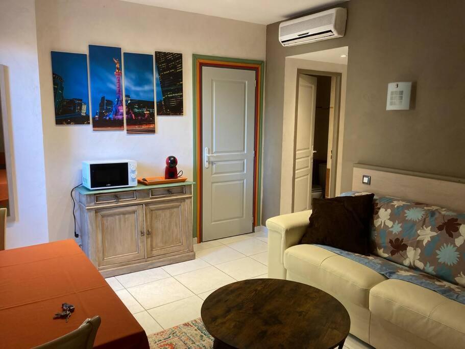 uma sala de estar com um sofá e uma mesa em Appartement « Mexico », Avignon em Avignon