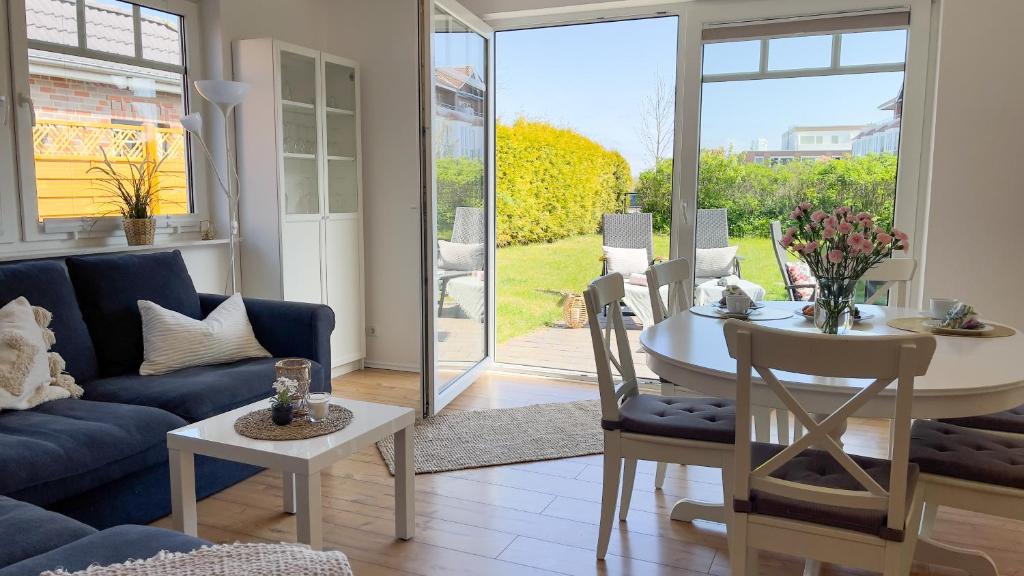 a living room with a blue couch and a table at Haus Eversand Nr 2 in Cuxhaven