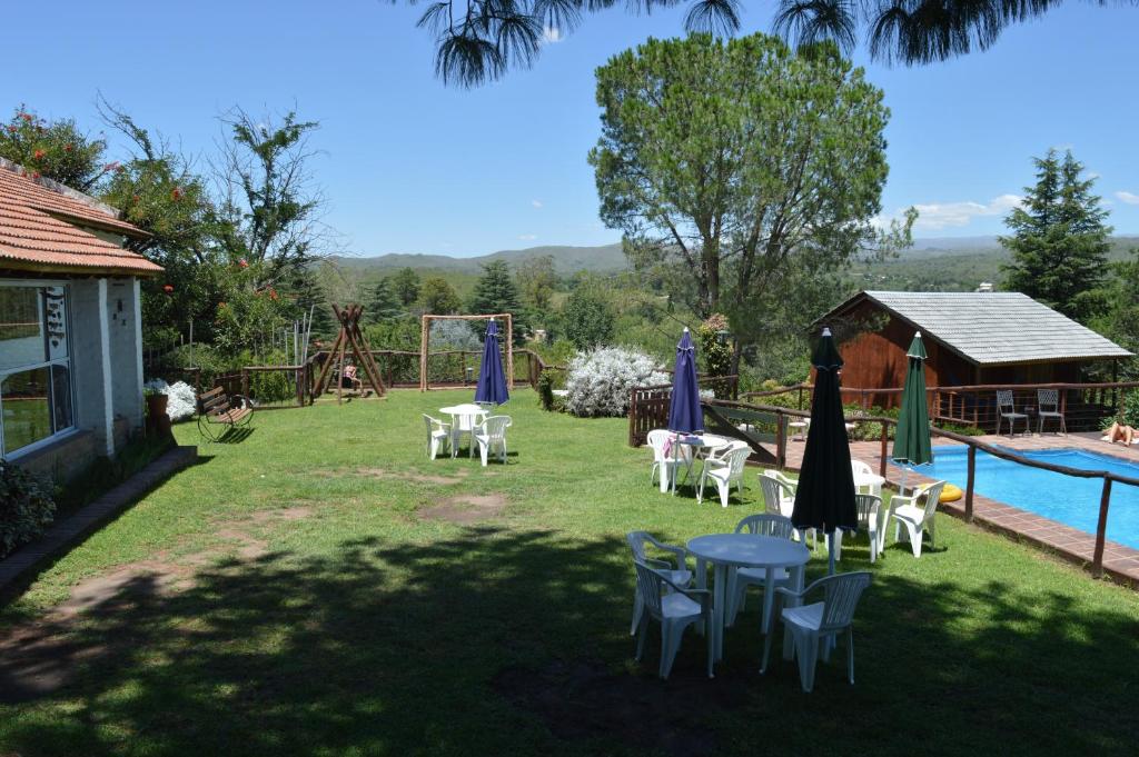 un patio con mesas y sillas y una piscina en Cabañas El Mirador de Icho Cruz en Villa Icho Cruz