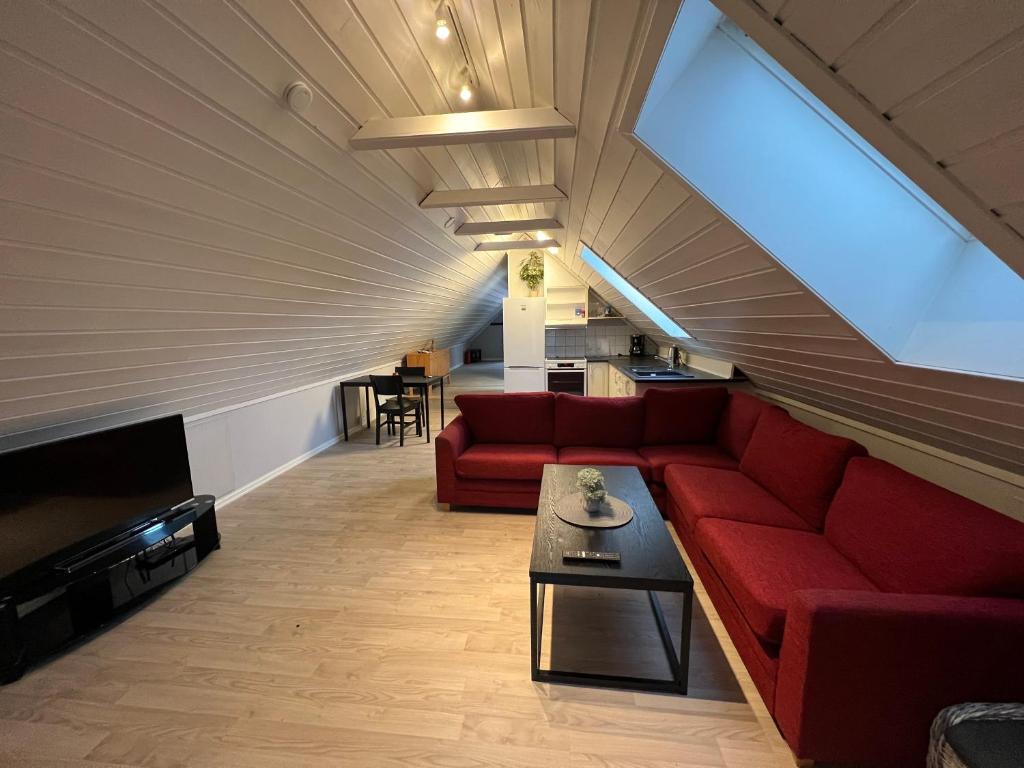 sala de estar con sofá rojo y mesa en MyCondo no - Øvre Langgate 24 - gratis parkering en Tønsberg