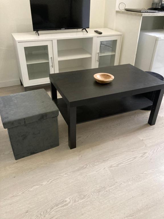 - une table basse noire et un banc dans le salon dans l'établissement Appartement Paris 17, à Paris