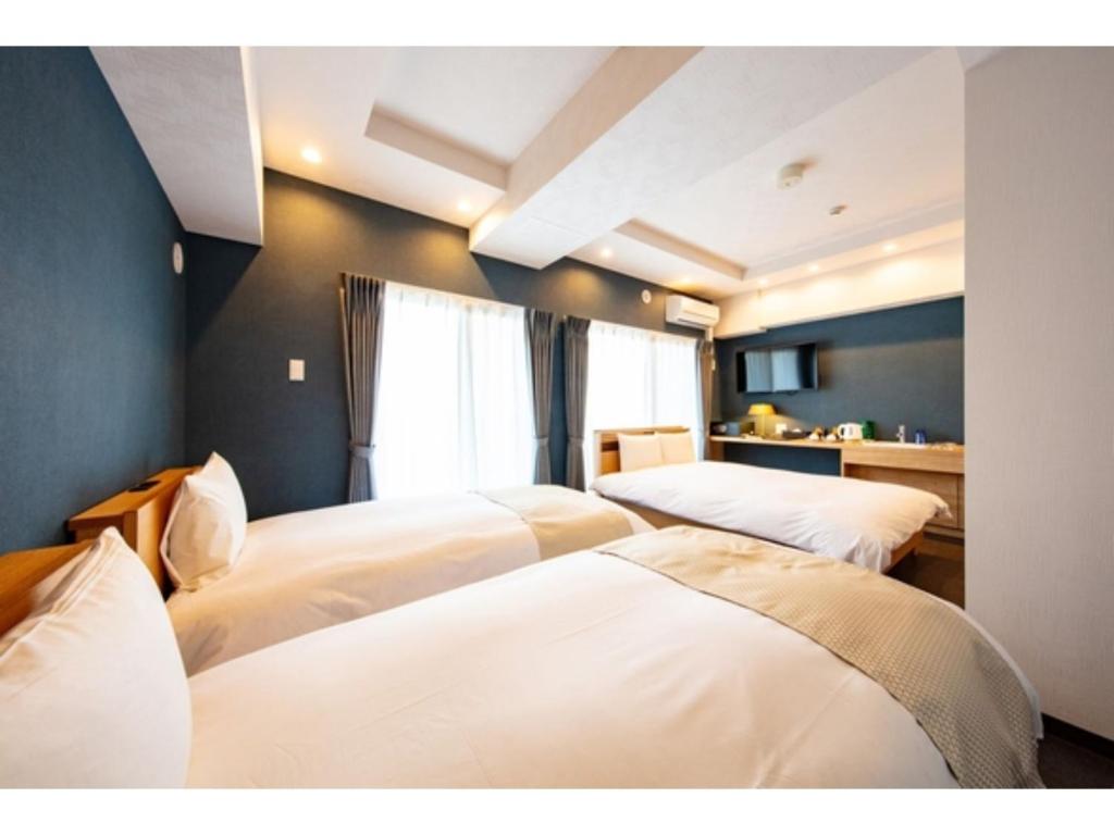 1 Schlafzimmer mit 3 Betten in einem Zimmer in der Unterkunft VILLA KOSHIDO KOTONI - Vacation STAY 49614v in Sapporo